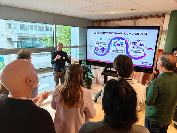 Presentator geeft bij AI-land een demo naast een scherm met de titel 'AI-dienstverlening op jouw open data'