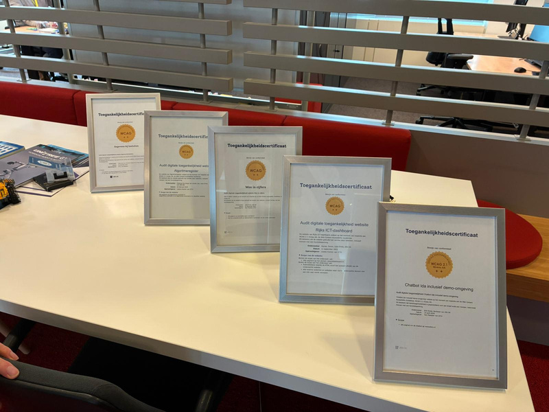 Vijf ingelijste toegankelijkheidscertificaten, waaronder het certificaat voor chatbot IDA